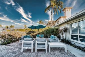 Un patio con una mesa y sillas y una sombrilla. en Waterfront Villa Heated Pool Spa Walk To Beach, en Fort Lauderdale
