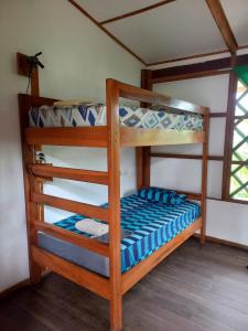 two bunk beds in a room with a window at Pagalù Hostel in Puerto Viejo