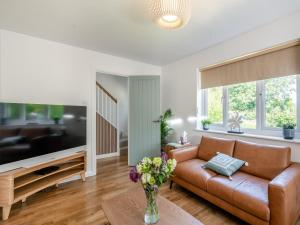 a living room with a couch and a tv at Norfolk Broads And Coast, Malthouse Cottage in Ranworth