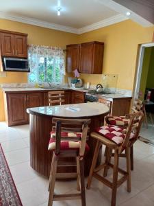 una cucina con tavolo rotondo e sedie di Sevelle Meadows 2 Extended Stay a Spanish Town