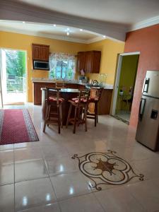 a kitchen with a table and chairs and a refrigerator at Sevelle Meadows 2 Extended Stay in Spanish Town
