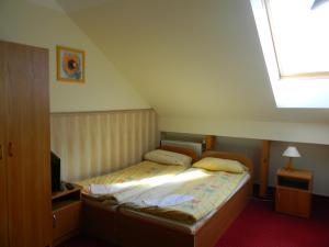 a small bedroom with a bed with a skylight at Prohibicja Peter's Pub in Mikołajki