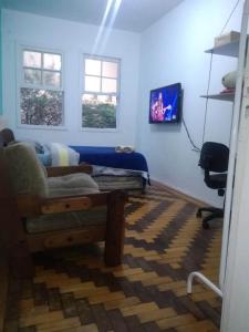 a bedroom with a bed and a desk and a chair at Sobrado Tranquilo Centro in Porto Alegre