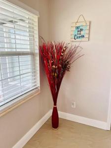 a red vase with red flowers in a room at Busch Gardens Deluxe Edition w/heatedpool in Tampa