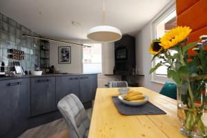 a kitchen with a wooden table with a vase of sunflowers at BohoStyleApartment am See in Schluchsee