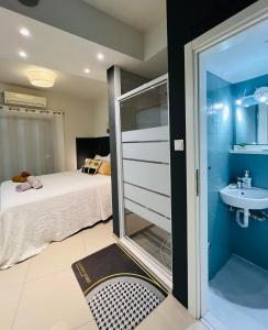 1 dormitorio con cama, lavabo y espejo en Elli’s Home, en Tesalónica