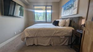 1 dormitorio con cama y ventana en Echo Landing #37 condo, en Sun Peaks
