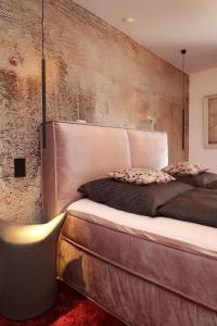 ein Schlafzimmer mit einem großen Bett und einer Betonwand in der Unterkunft BohoStyleApartment am See in Schluchsee