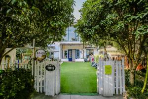 a white fence in front of a building with a yard at Gala Seeker INN in Hangzhou