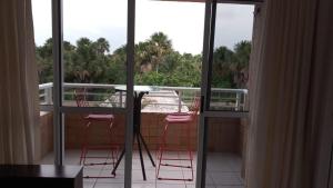 balcone con sedie rosa e tavolo. di Gran solare Lençois (flat) a Barreirinhas