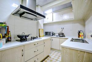 uma grande cozinha com um fogão e um lavatório em Gala Seeker INN em Hangzhou
