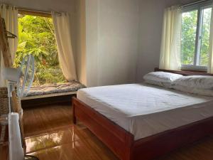 a bedroom with two beds and a window at Sheila’s Villa in Leyte