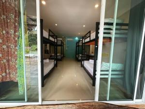 een kamer met meerdere stapelbedden en een raam bij Painting Family Hostel in Khao Sok