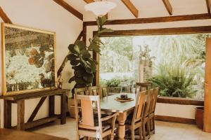 a dining room with a table and chairs and a window at Misty Mountain Manor in Uki