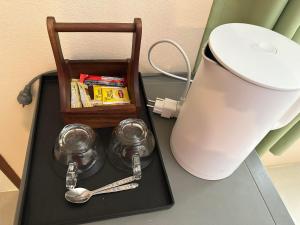 a table with a lamp and a tray with spoons at Painting Family Hostel in Khao Sok