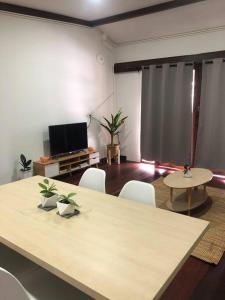 Una habitación con una mesa y sillas y un televisor. en Wooden house in the centre of Chiangmai self-checkin, en Chiang Mai