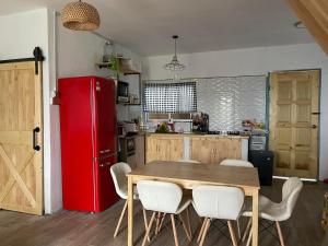 a kitchen with a wooden table and a red refrigerator at The M Wanderlust Private Cabin in Ranau