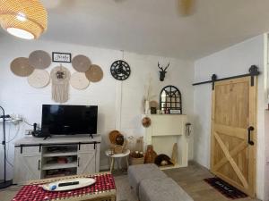 een woonkamer met een tv en een schuifdeur bij The M Wanderlust Private Cabin in Ranau