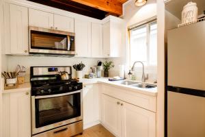 eine Küche mit weißen Schränken und einem Herd und einer Spüle in der Unterkunft The Eagles Nest Hot Tub BBQ Modern Retreat in Sugarloaf