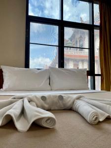 ein weißes Bett mit einem großen Fenster in einem Zimmer in der Unterkunft Wantana Mansion in Hat Yai