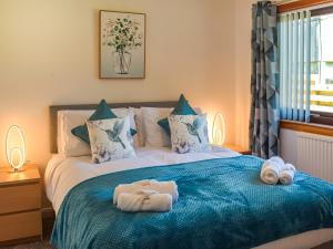 a bedroom with a bed with towels on it at Lowesmuir Cottage in Cumnock