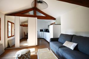 uma sala de estar com um sofá azul e uma cozinha em Studio * Confort * Sérénité * La halte du Pèlerin em Bures-sur-Yvette