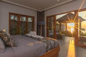 a bedroom with a bed and a view of the ocean at Villa Sean in Lovina
