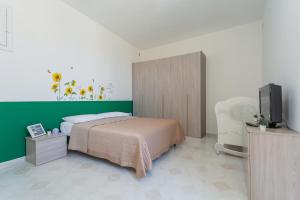 Schlafzimmer mit einem Bett und einem Flachbild-TV in der Unterkunft Casa Bianca bnb Big Terrace 10min Airport, Beach in Bitonto