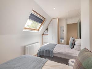 a small bedroom with two beds and a window at Norfolk Broads And Coast, Malthouse Cottage in Ranworth