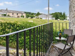 a table and two chairs on a balcony with a field at 1 The Old Corn Mill in Middleham