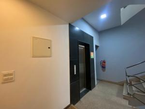 un pasillo con una puerta negra y una boca de incendios en F9 Hotels 343 Meera Bagh, Paschim Vihar en Nueva Delhi