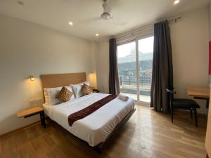 a bedroom with a large bed and a large window at F9 Hotels 343 Meera Bagh, Paschim Vihar in New Delhi
