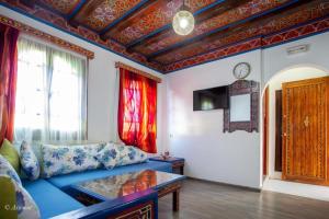 - un salon avec un canapé bleu et une table dans l'établissement Guest House Yasmina, à Chefchaouen
