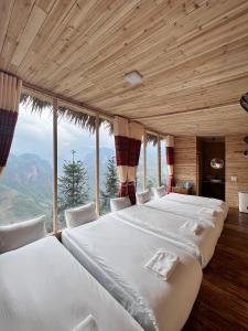 2 camas en una habitación con ventana grande en Mã Pì Lèng EcoLodge en Mèo Vạc