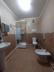 a bathroom with two sinks and a shower and two toilets at Apart-hotel 24/7 in Kamianets-Podilskyi