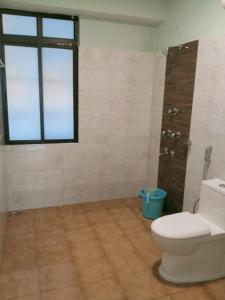 y baño con aseo, ventana y ducha. en Hotel BJ en Gangtok