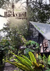 een bord waarop staat dat de achtertuin naast een huis kampeert bij The Backyard Glamping Cameron Highlands in Tanah Rata