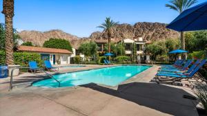 a swimming pool with chairs and umbrellas in a resort at LV204 Airy Upstairs 2 Bedroom w Private Balcony in La Quinta
