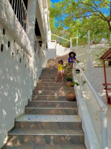 two women standing on the stairs of a house at Vito Hotel Boutique in Taganga