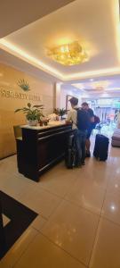 two people standing at a reception desk in a hotel lobby at Rising Dragon Hotel in Hanoi