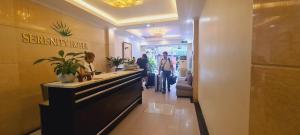 a lobby of a store with people standing at a counter at Rising Dragon Hotel in Hanoi