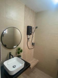 a bathroom with a sink and a mirror at My Cozy 2-bedroom Apartment in Melaka