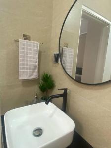 uma casa de banho com um lavatório branco e um espelho. em My Cozy 2-bedroom Apartment em Malaca