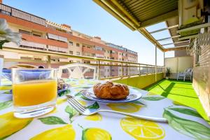 uma mesa com um copo de sumo de laranja e um prato de comida em Apartamento Litoral Blue em Málaga