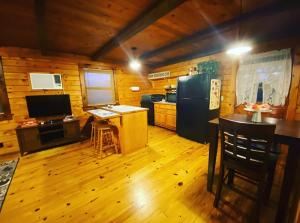 Cozy Cabin at Bear Mountain Log Cabins في يوريكا سبرينغز: مطبخ مع ثلاجة وطاولة في الغرفة