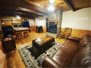 sala de estar con sofá y chimenea en Cozy Cabin at Bear Mountain Log Cabins en Eureka Springs