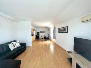 比亞拉的住宿－Апартамент Съни Хаус - Sunny House Apartment，客厅配有黑色沙发和平面电视。