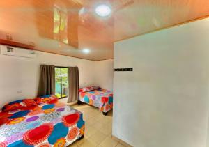 1 Schlafzimmer mit 2 Betten und einem Fenster in der Unterkunft Carey Lodging in Tortuguero