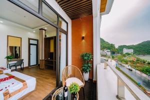um quarto com uma varanda com vista para a cidade em Gia Cat Long Hotel em Ilha de Cát Bà