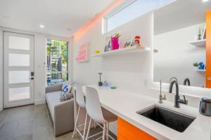 a kitchen with a sink and a counter with chairs at Orange Container @EADO Juice Box in Houston